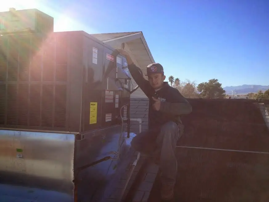 HVAC technician performing Heat Pump Repair on a rooftop unit in South Lake Tahoe